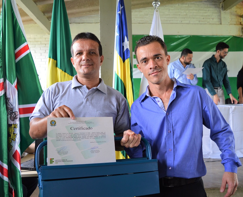 Professor Carlos Roberto entrega caixa de ferramentas para concluinte